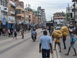 Pedestrians and motorbikes share a lane designated for buses in Dar es Salaam.