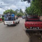 A red Datsun and white Toyota truck in El Salvador.