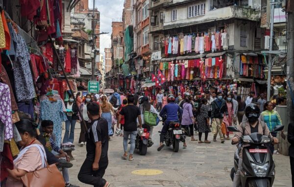 A street in Kathmandu, with clothing for sale outside buildings.